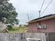 Back of house with yard, wooden fence, and electrical box at 136 Madera Dr, Winter Haven, FL 33880