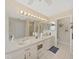 Double vanity bathroom with a large mirror and updated lighting at 2163 Rainbower Ct, Lakeland, FL 33810