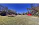 Open grassy backyard with red barn and trees at 1335 Dean St, Mulberry, FL 33860