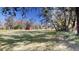 Open grassy backyard with trees and red barn at 1335 Dean St, Mulberry, FL 33860