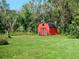 Red barn with wagon wheels and barrels in front at 1335 Dean St, Mulberry, FL 33860