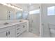 Modern bathroom with double vanity, large mirror and a glass shower at 485 Adams View Ln, Auburndale, FL 33823