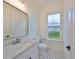 Clean and modern bathroom with white vanity and patterned tile floor at 485 Adams View Ln, Auburndale, FL 33823