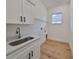 Laundry room with white cabinets, quartz countertop, and a utility sink at 485 Adams View Ln, Auburndale, FL 33823