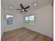 Bedroom with hardwood floors, ceiling fan and two windows offering natural light at 485 Adams View Ln, Auburndale, FL 33823