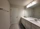Double vanity bathroom with a large mirror and grey floor tiles at 1564 Eucalyptus Way, Davenport, FL 33837