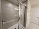 Shower with glass enclosure, built-in seat, and gray tile at 1564 Eucalyptus Way, Davenport, FL 33837