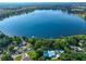 Aerial view of a lakefront house with a pool and lush greenery at 220 Coleman E Dr, Winter Haven, FL 33884