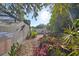 Landscaped backyard with lush plants, stone pathway, and privacy fence at 220 Coleman E Dr, Winter Haven, FL 33884