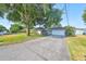 Single-story house with a large tree, driveway, and attached garage at 220 Coleman E Dr, Winter Haven, FL 33884