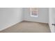 Well-lit bedroom featuring neutral carpeting and a window at 4270 Sw 143Rd Lane Rd, Ocala, FL 34473