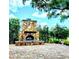 Outdoor patio with a stone fireplace and brick pavers at 5446 Pebble Beach Dr, Lakeland, FL 33812