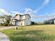 Two story house with light beige walls, brown roof, and a two car garage at 210 Kenny Blvd, Haines City, FL 33844