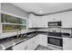 Updated kitchen boasts white cabinets, black marble countertops, and stainless steel appliances at 3419 Lisa Ln, Lakeland, FL 33801