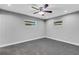 Well-lit bedroom with grey carpet, ceiling fan and two windows at 3419 Lisa Ln, Lakeland, FL 33801