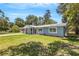 Newly renovated light blue home with landscaping and a metal roof at 3419 Lisa Ln, Lakeland, FL 33801