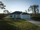 Front view of house with driveway and grassy yard at 7811 Red Grange Blvd, Indian Lake Estates, FL 33855