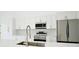Modern kitchen featuring stainless steel appliances and white shaker cabinets at 7811 Red Grange Blvd, Indian Lake Estates, FL 33855