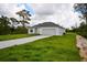 One-story house with a two-car garage and a large grassy yard at 7811 Red Grange Blvd, Indian Lake Estates, FL 33855