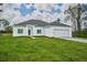 Single story home with a two-car garage and grassy yard at 7811 Red Grange Blvd, Indian Lake Estates, FL 33855