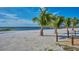 Scenic beach access with palm trees and a pier at 7811 Red Grange Blvd, Indian Lake Estates, FL 33855