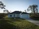 Front view of house with driveway and grassy yard at 7811 Red Grange Blvd, Indian Lake Estates, FL 33855