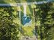 Aerial view of a house on a tree-lined property at 7811 Red Grange Blvd, Indian Lake Estates, FL 33855