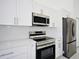 Modern kitchen with stainless steel appliances and white shaker cabinets at 7811 Red Grange Blvd, Indian Lake Estates, FL 33855