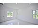 Bright bedroom with two windows, white walls, and marble-look tile flooring at 7811 Red Grange Blvd, Indian Lake Estates, FL 33855