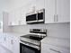 Modern kitchen with stainless steel appliances and white shaker cabinets at 7811 Red Grange Blvd, Indian Lake Estates, FL 33855