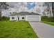 Front view of house, showing garage and yard at 7811 Red Grange Blvd, Indian Lake Estates, FL 33855
