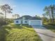 Newly constructed one-story home with a two-car garage and a spacious lawn at 7811 Red Grange Blvd, Indian Lake Estates, FL 33855