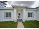 Modern front entrance with a glass door and gray accents at 7811 Red Grange Blvd, Indian Lake Estates, FL 33855