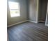 Simple bedroom with gray walls and wood-look flooring at 1008 Ne 5Th St, Mulberry, FL 33860