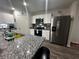 Kitchen features granite countertops and stainless steel fridge at 319 Hibiscus Dr, Kissimmee, FL 34759