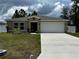Single story home with two car garage and landscaped lawn at 319 Hibiscus Dr, Kissimmee, FL 34759