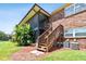 Back exterior view of the property showing the stairs and screened porch at 1920 E Edgewood Dr # M2, Lakeland, FL 33803