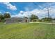 Gray house with red door, green lawn, and a driveway at 1075 8Th Nw St, Winter Haven, FL 33881