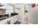 Small galley style kitchen with white cabinets and granite counters at 1075 8Th Nw St, Winter Haven, FL 33881