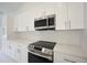 Sleek kitchen with stainless steel appliances and white cabinets at 2851 Palm Ave, Indian Lake Estates, FL 33855