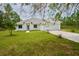 Charming single-story house with a white exterior and a lush green lawn at 2851 Palm Ave, Indian Lake Estates, FL 33855