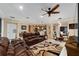 Open concept living room with leather sofas and views into kitchen and dining areas at 7067 Sw 91St Ct, Ocala, FL 34481