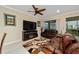 Relaxing living room featuring leather couches and a fireplace at 7067 Sw 91St Ct, Ocala, FL 34481