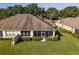 Rear view of house showing screened patio, landscaping, and neighboring homes at 7067 Sw 91St Ct, Ocala, FL 34481