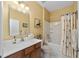 Bathroom with tub shower combo, vanity, and decorative curtain at 7067 Sw 91St Ct, Ocala, FL 34481