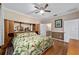 Main bedroom with hardwood floors, large bed, and ensuite bathroom access at 7067 Sw 91St Ct, Ocala, FL 34481