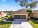 Exterior view of a tan house with a screened garage at 7067 Sw 91St Ct, Ocala, FL 34481