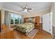 Spacious bedroom with hardwood floors, ceiling fan, and large window at 7067 Sw 91St Ct, Ocala, FL 34481