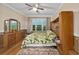 Bright bedroom with hardwood floors, ceiling fan, and mirrored wardrobe at 7067 Sw 91St Ct, Ocala, FL 34481