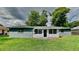 House exterior showcasing a screened porch and well-maintained lawn at 1737 Jacobs Rd, South Daytona, FL 32119